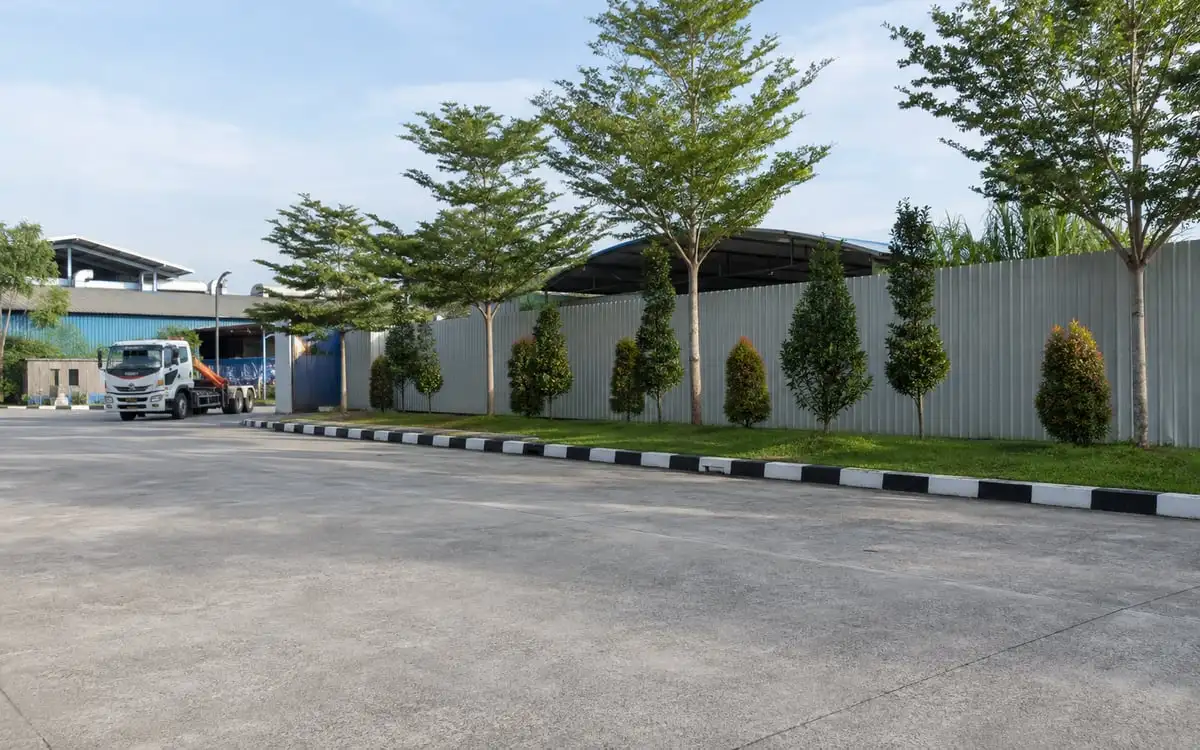 Illustration of a cleared industrial car park and tidy tropical verge.